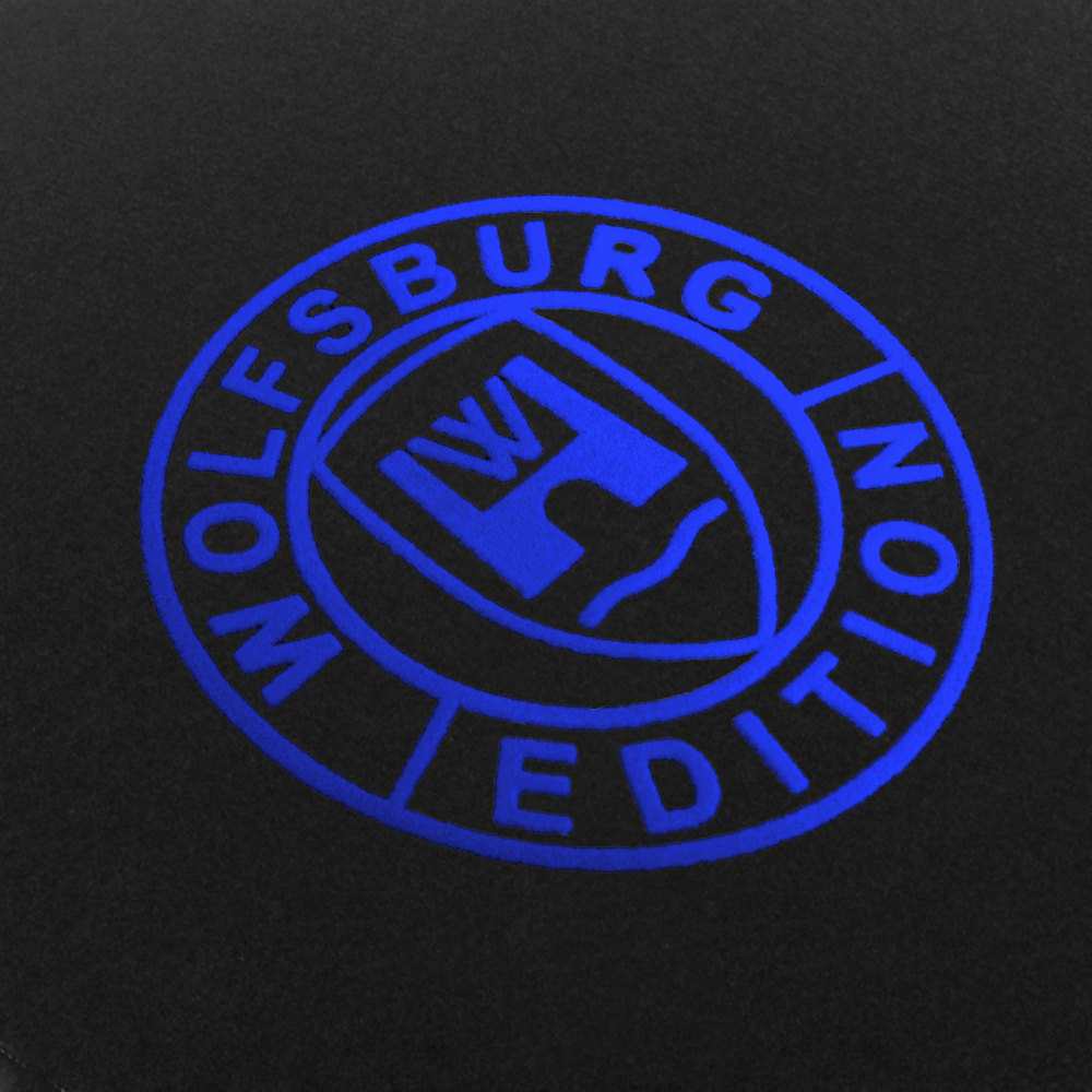 Das Wolfsburg Editions Logo auf einem schwarzen Teppich und das Logo ist in royalblau.