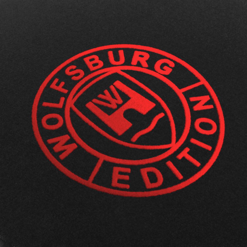 Das Wolfsburg Editions Logo auf einem schwarzen Teppich und das Logo ist in rot.